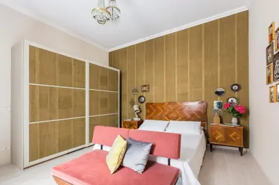 a bedroom with a bed and a red chair at Dandy Suite in Rome
