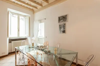 a dining room with a glass table and chairs at A Window on Pantheon in Rome