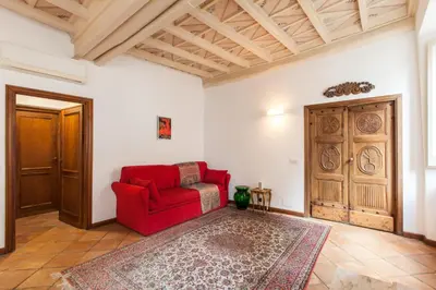 a living room with a red couch and a door at A Window on Pantheon in Rome