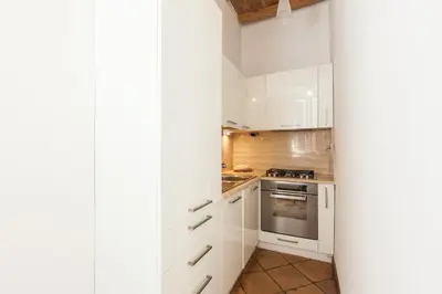 a kitchen with white cabinets and a stove at A Window on Pantheon in Rome