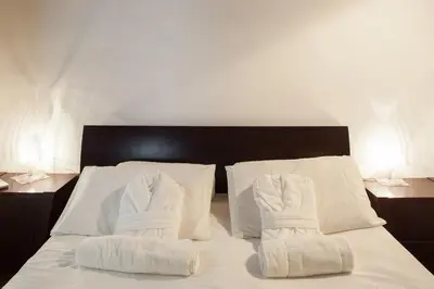 a bed with white blankets and pillows on it at A Window on Pantheon in Rome