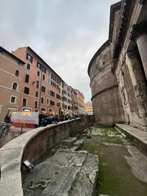a river in a city next to a building at A Window on Pantheon in Rome