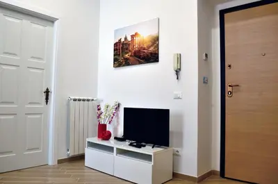a living room with a television on a white cabinet at Sweet Roman Dream in Rome