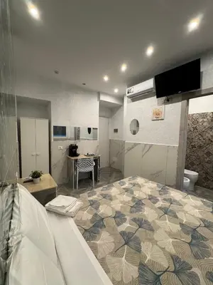 a room with a large bed with a flower pattern at LUXOR ECO ROMA CASA E APPARTAMENTO PER VACANZE IN CENTRO Piazza Bologna, Colosseo, Piazza di Spagna, Vaticano, San Pietro, Sapienza, Fontana di Trevi, Piazza Navona, Trastevere, Tiburtina, Termini, Aeroporto in Rome