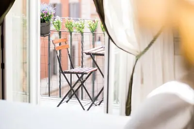 a balcony with two chairs and plants on a fence at Relais Donna Lucrezia in Rome