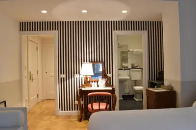 a room with a bed and a desk with a lamp at Relais Donna Lucrezia in Rome