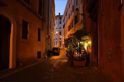 an empty street at night with a car parked on the street at Lupa Flat in Rome