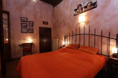 a bedroom with a bed with an orange comforter at Lupa Flat in Rome