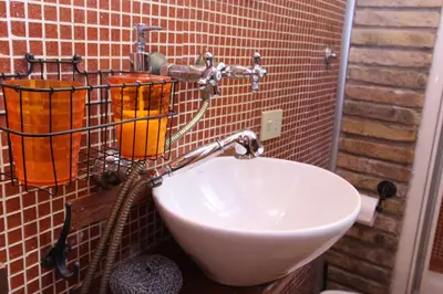 a bathroom with a sink and a red brick wall at Lupa Flat in Rome