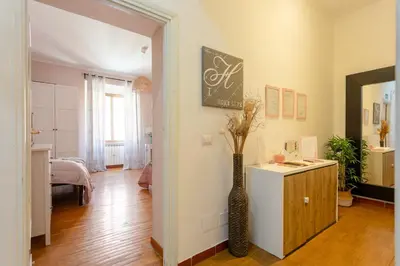 a woman is standing next to a bed at Florje House in Rome