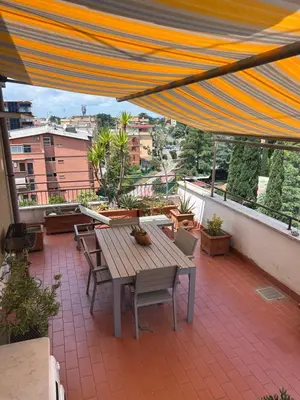 a patio with a wooden table and chairs on a balcony at Appartamento con Terrazza vicino Gemelli e Vaticano in Rome