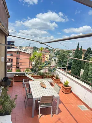 a patio with a table and chairs on a balcony at Appartamento con Terrazza vicino Gemelli e Vaticano in Rome
