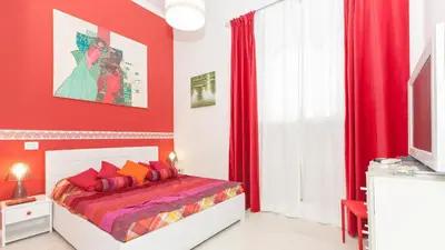 a bedroom with red walls and a bed with red curtains at Rental in Rome Palermo apartment in Rome
