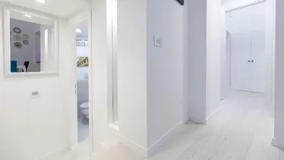 a white hallway with white walls and a mirror at Rental in Rome Palermo apartment in Rome