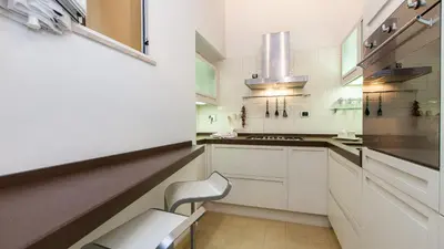 a kitchen with white cabinets and a chair in it at Rental in Rome Mial house in Rome