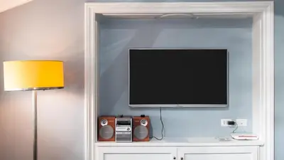 a flat screen tv on a wall next to a lamp at Rental in Rome Flaminio View Suite in Rome