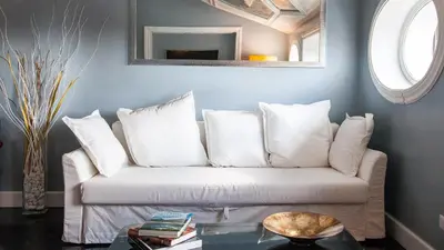 a living room with a white couch with pillows at Rental in Rome Flaminio View Suite in Rome