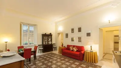 a living room with a red couch and a table at Rental in Rome Ghetto Garden in Rome