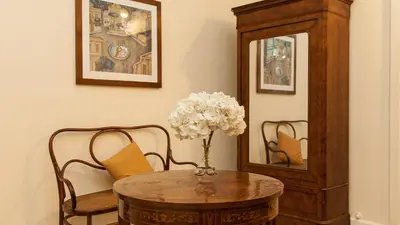 a table with a vase of flowers on top at Rental in Rome Ghetto Garden in Rome