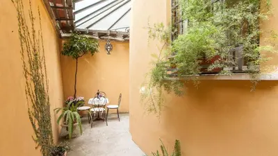 a woman sitting at a table in a courtyard at Rental in Rome Ghetto Garden in Rome