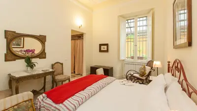 a bedroom with a bed with a red blanket on it at Rental in Rome Ghetto Garden in Rome