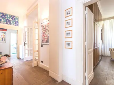 a hallway of a home with white walls and wooden floors at Villa Michelangelo Deluxe in Rome