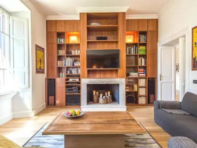 a living room with a fireplace and bookshelves at Villa Michelangelo Deluxe in Rome