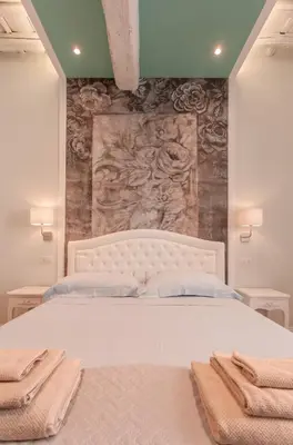 a bedroom with a large white bed with towels on it at Boschetto 124 Apartment in Rome