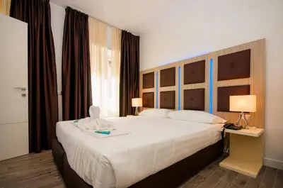 a bedroom with a large white bed with a headboard at Vatican Relais Rome in Rome