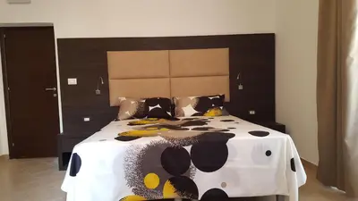 a large bed with a black and white comforter at Una Finestra su Monti in Rome