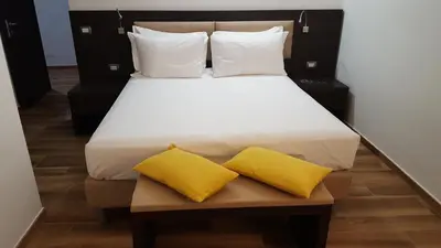 a large bed with two yellow pillows on it at Una Finestra su Monti in Rome