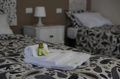 a pile of towels and a bottle on a bed at My Sweet Rome Guest House in Rome
