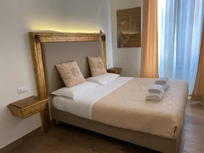 a bedroom with a bed with white sheets and pillows at Art Atelier Accomodation Guest House in Rome