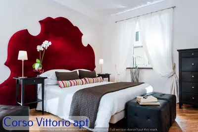 a bedroom with a large bed with a red headboard at Corso Vittorio Apartments in Rome
