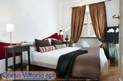 a bedroom with a bed with a table and a window at Corso Vittorio Apartments in Rome