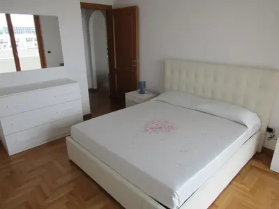 a bedroom with a white bed and a dresser at Pianeta Roma 45 in Rome