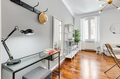 a living room with a glass desk and a chair at Appartamenti con vista Piazza Testaccio in Rome