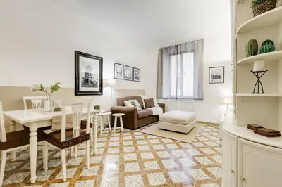 a dining room and living room with a table and a couch at Appartamenti con vista Piazza Testaccio in Rome