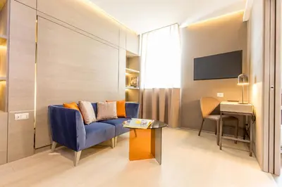 a living room with a blue couch and a table at Orazio Palace Hotel in Rome