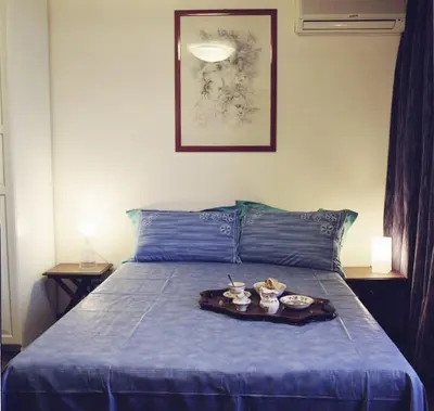 a blue bed with a tray of food on it at B&B Buongiornoroma in Rome
