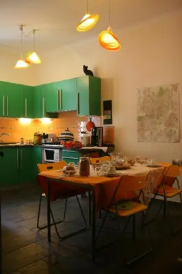a kitchen with green cabinets and a table with chairs at B&B Buongiornoroma in Rome