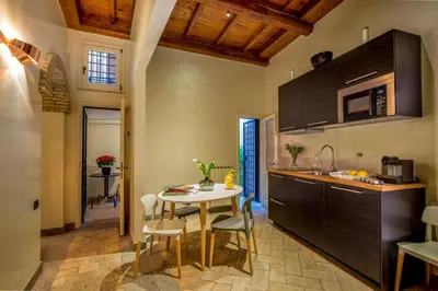 a kitchen with a table and chairs in a room at Palazzo Medusa in Rome