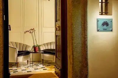 a room with chairs and a table with a vase at Palazzo Medusa in Rome