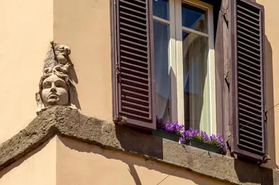 a statue on the side of a building with a window at Palazzo Medusa in Rome