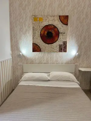 a bed in a bedroom with a painting on the wall at Eufonia Vatican Days in Rome