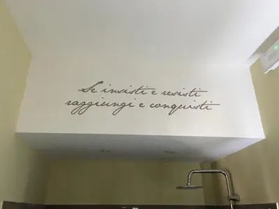 a sign on the ceiling above a sink in a bathroom at Domus Corsini in Rome
