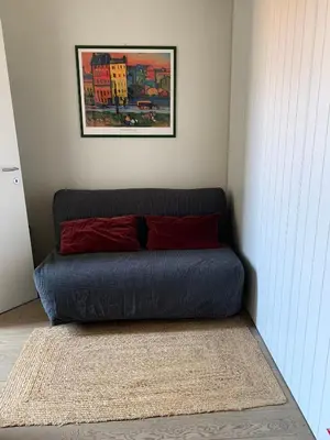a blue couch with two red pillows in a room at L'Attichetto di Ponte Milvio a Roma Centro in Rome