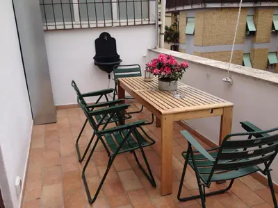 a table and chairs on a balcony with flowers on it at L'Attichetto di Ponte Milvio a Roma Centro in Rome