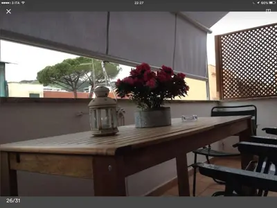 a table with a vase of flowers and a lamp at L'Attichetto di Ponte Milvio a Roma Centro in Rome