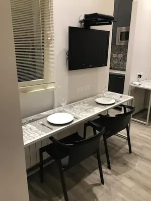 a kitchen with a table with two chairs and a television at Rome Studio Rental in Rome